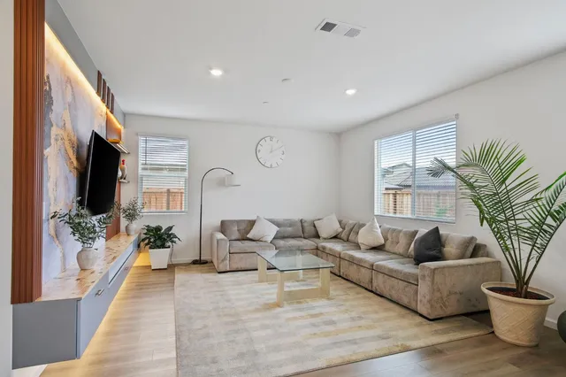 a living room with furniture a large window and a flat screen tv