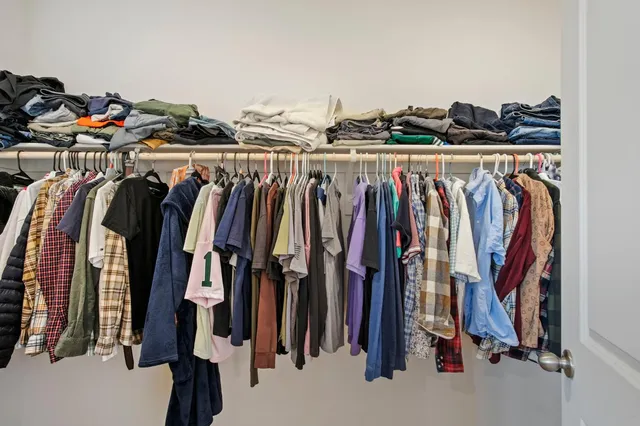 a view of walk in closet with clothes and shoes