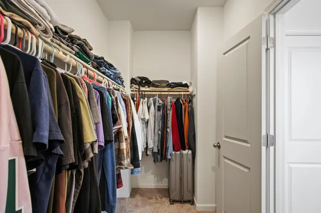 a view of walk in closet with clothes