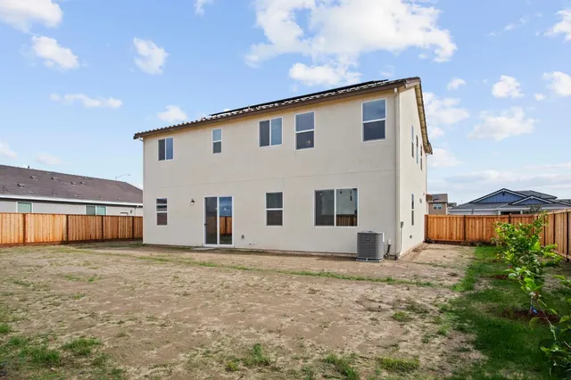 a view of a house with big yard and large tree