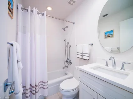 a bathroom with a sink a toilet a mirror and shower