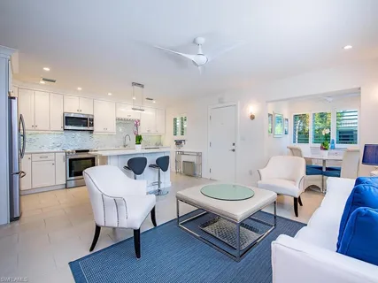 a living room with furniture and a view of kitchen