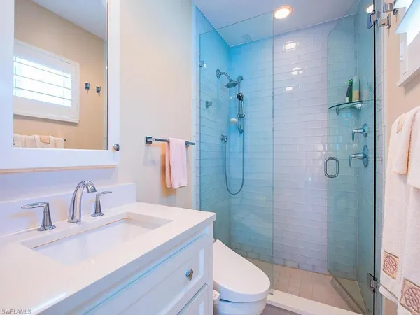 a bathroom with a sink a toilet and shower