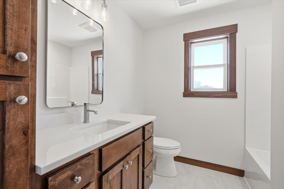 622 Sundance Street Amery, WI 54001 - Photo 15 of 24 Full bath with continued dark wood and white accents!