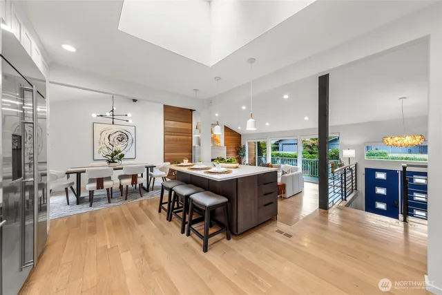 a kitchen with stainless steel appliances granite countertop a stove oven and a dining table with wooden floor