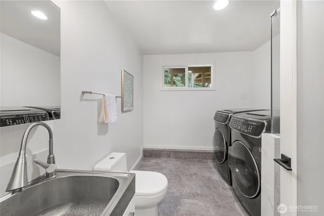 a utility room with sink dryer and washer