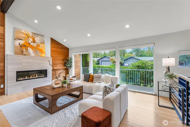 a living room with furniture a fireplace and a floor to ceiling window