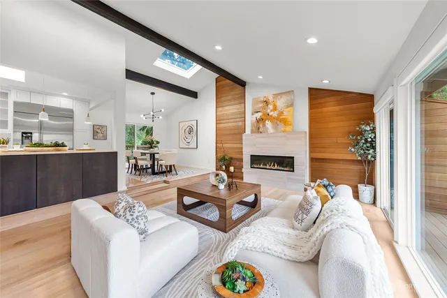 a living room with fireplace furniture and a large window
