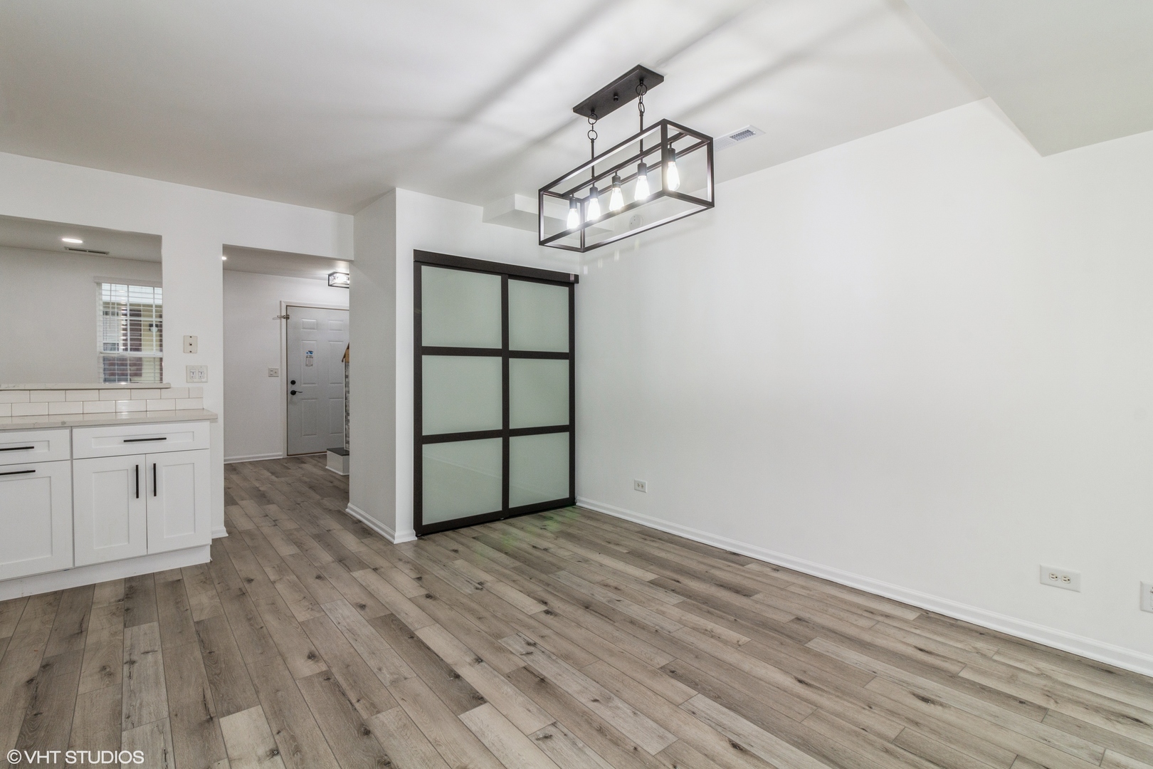 1061 Symphony Drive Aurora, IL 60504 - Photo 4 of 10 an empty room with wooden floor cabinet and windows