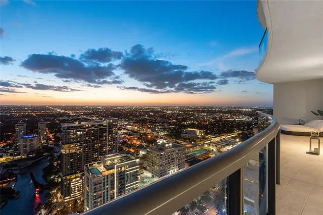 an aerial view of a city with lots of residential buildings ocean and mountain view in back