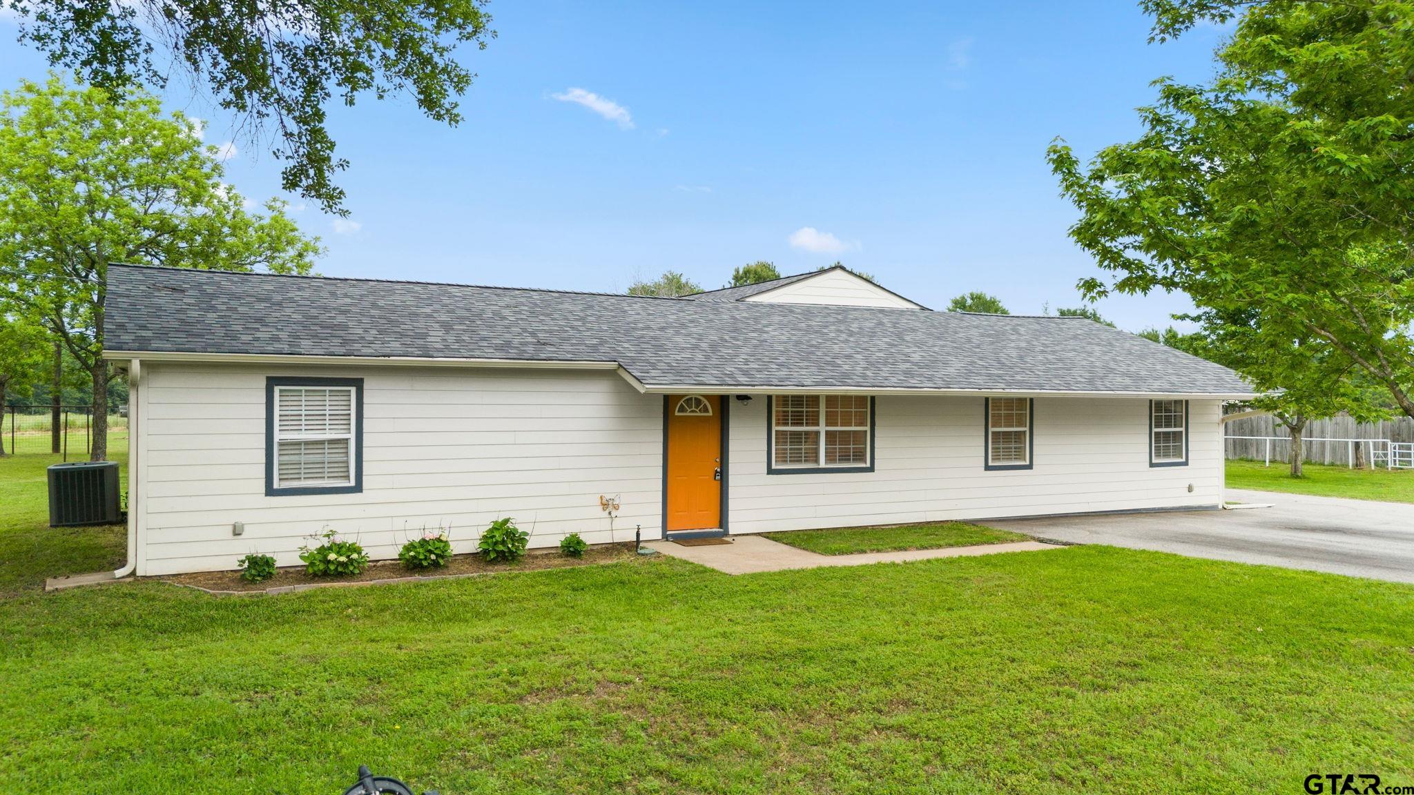 a front view of house with yard and trees