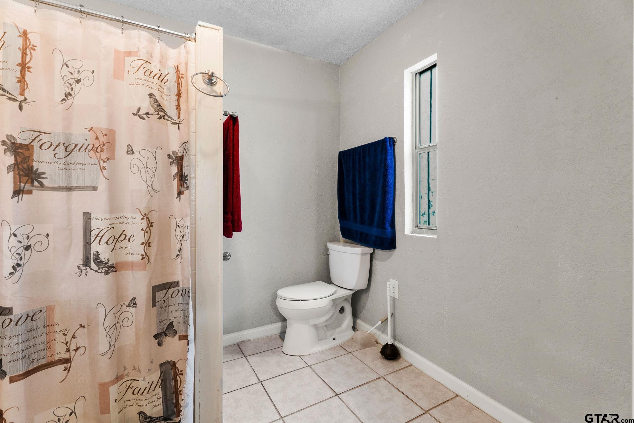 6091 Mockingbird Lane Murchison, TX 75778 - Photo 13 of 33 a bathroom with a toilet and a shower curtain