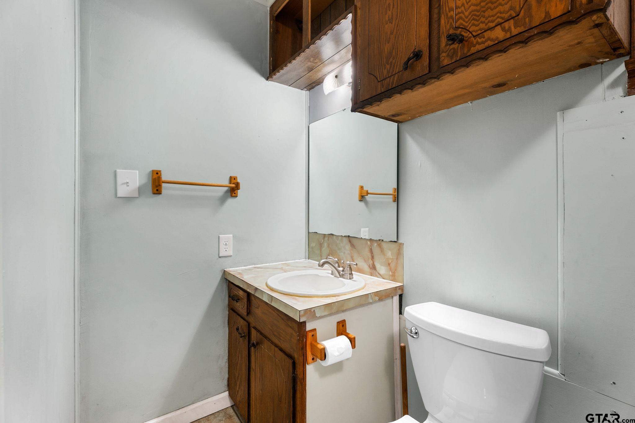 6091 Mockingbird Lane Murchison, TX 75778 - Photo 15 of 33 a bathroom with a sink a toilet and a mirror