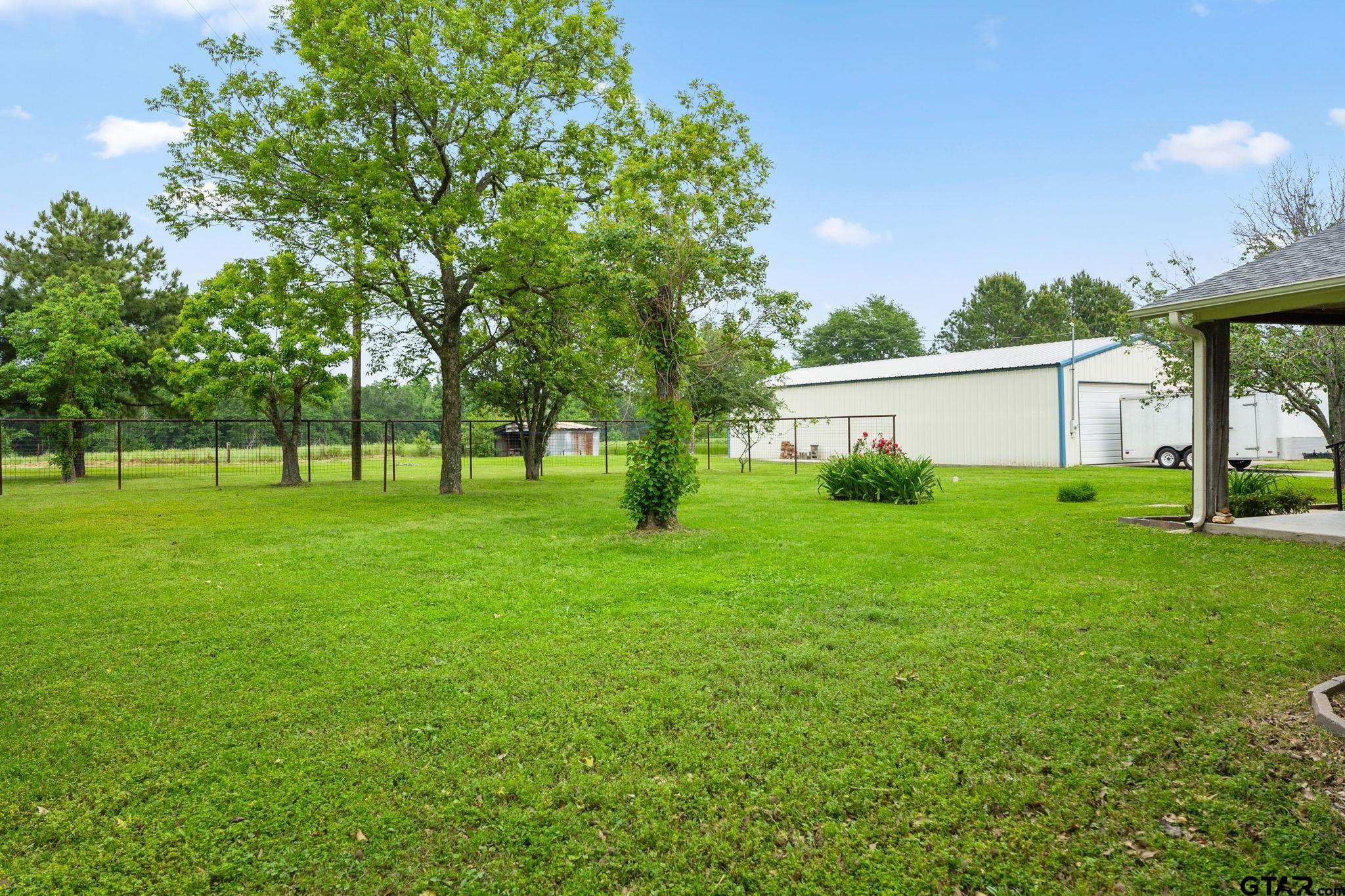 6091 Mockingbird Lane Murchison, TX 75778 - Photo 26 of 33 a view of a white house in front of a big yard with plants and large trees