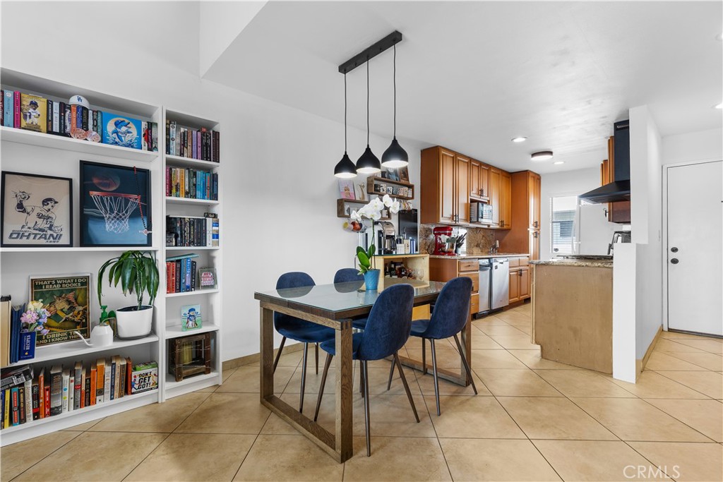 20134 Leadwell Street, Unit 332 Winnetka, CA 91306 - Photo 5 of 14 a view of a dining room with furniture and a book shelf