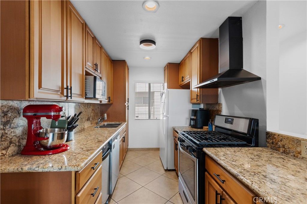20134 Leadwell Street, Unit 332 Winnetka, CA 91306 - Photo 6 of 14 a kitchen with stainless steel appliances granite countertop a stove and a sink