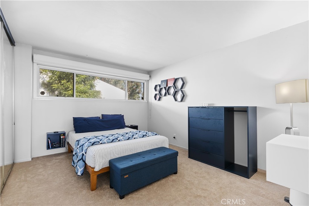 20134 Leadwell Street, Unit 332 Winnetka, CA 91306 - Photo 7 of 14 a bedroom with a bed and a lamp