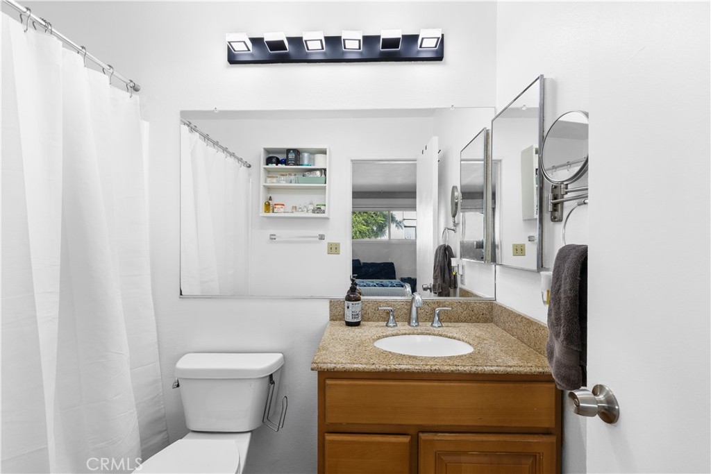 20134 Leadwell Street, Unit 332 Winnetka, CA 91306 - Photo 8 of 14 a bathroom with a toilet sink and mirror