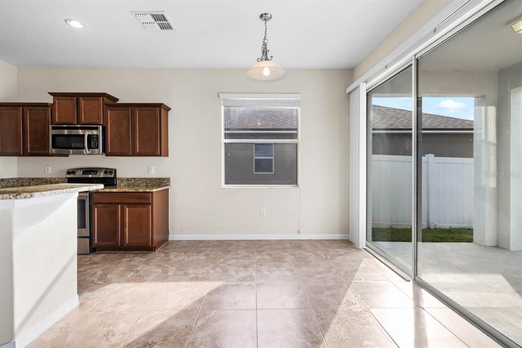 1504 Oak Pond Street Ruskin, FL 33570 - Photo 14 of 76 a kitchen with stainless steel appliances granite countertop a stove a sink and a refrigerator
