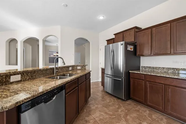 a kitchen with granite countertop wood cabinets and stainless steel appliances