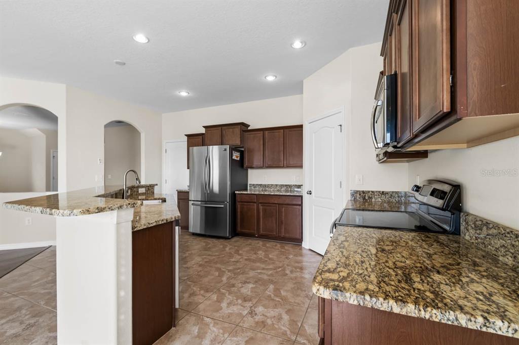 1504 Oak Pond Street Ruskin, FL 33570 - Photo 17 of 76 a kitchen with stainless steel appliances granite countertop a sink stove and refrigerator