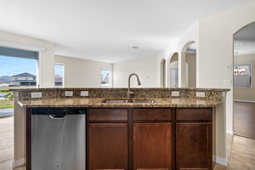 1504 Oak Pond Street Ruskin, FL 33570 - Photo 19 of 76 a kitchen with stainless steel appliances granite countertop a sink and a refrigerator