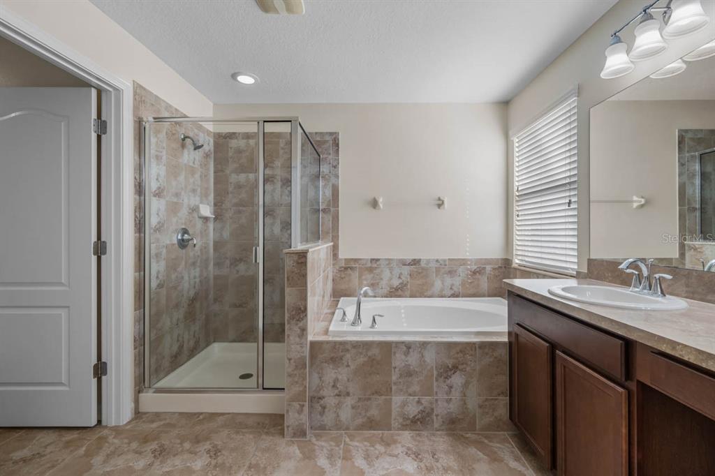 1504 Oak Pond Street Ruskin, FL 33570 - Photo 30 of 76 a bathroom with a granite countertop sink a shower and mirror