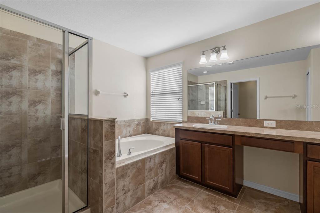1504 Oak Pond Street Ruskin, FL 33570 - Photo 31 of 76 a bathroom with a granite countertop sink mirror and a bathtub