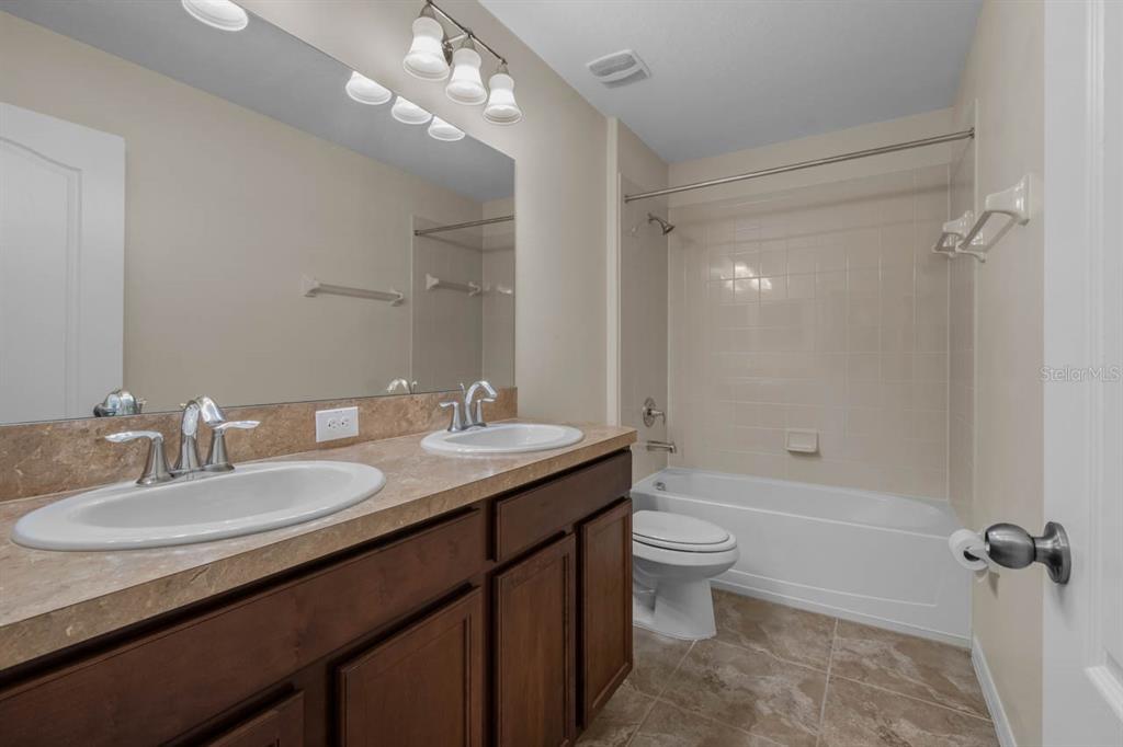 1504 Oak Pond Street Ruskin, FL 33570 - Photo 40 of 76 a bathroom with a granite countertop sink a toilet a mirror and shower