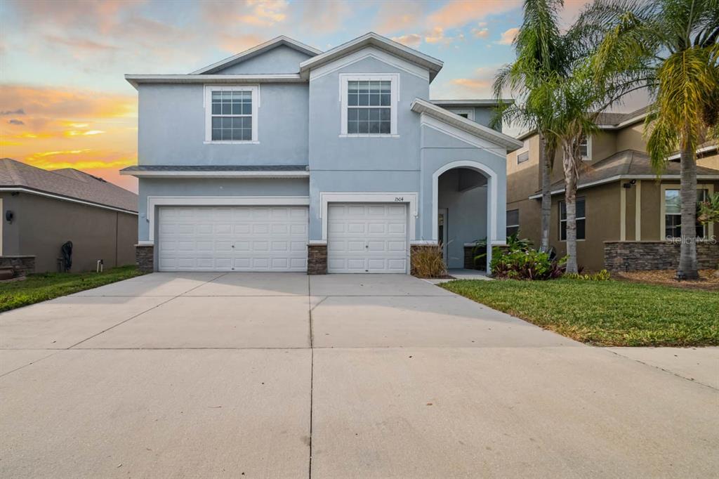 1504 Oak Pond Street Ruskin, FL 33570 - Photo 62 of 76 a front view of a house with a garden and garage