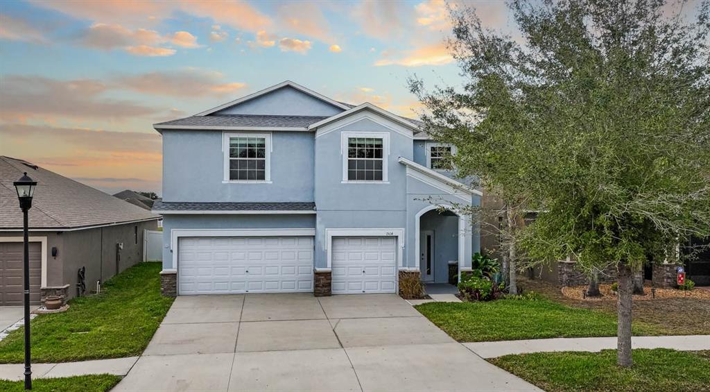 1504 Oak Pond Street Ruskin, FL 33570 - Photo 64 of 76 a front view of a house with a yard and garage