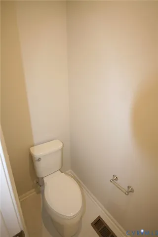a white toilet sitting next to a white wall