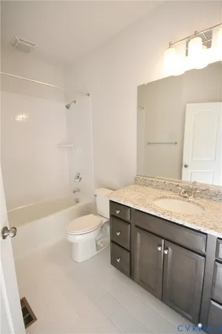 a bathroom with a granite countertop sink a toilet and bathtub