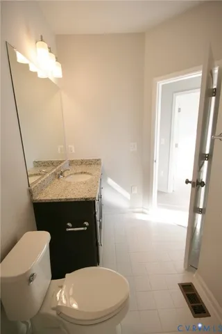 a bathroom with a sink a toilet a mirror and vanity