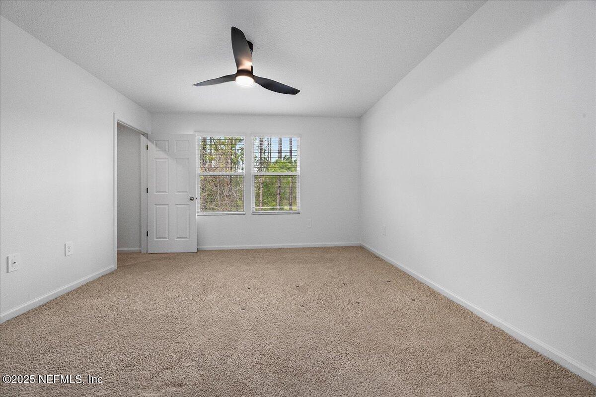 48 Barley Street St. Augustine, FL 32092 - Photo 11 of 24 an empty room with a chandelier fan and windows
