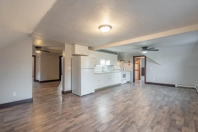 a view of a kitchen with wooden floor and a refrigerator