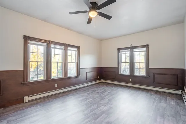 a view of an empty room with a window and wooden floor