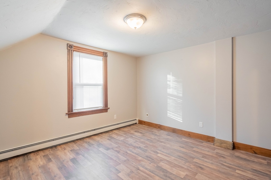 85 East Main Street, Unit 3 West Brookfield, MA 01585 - Photo 6 of 25 an empty room with wooden floor and windows