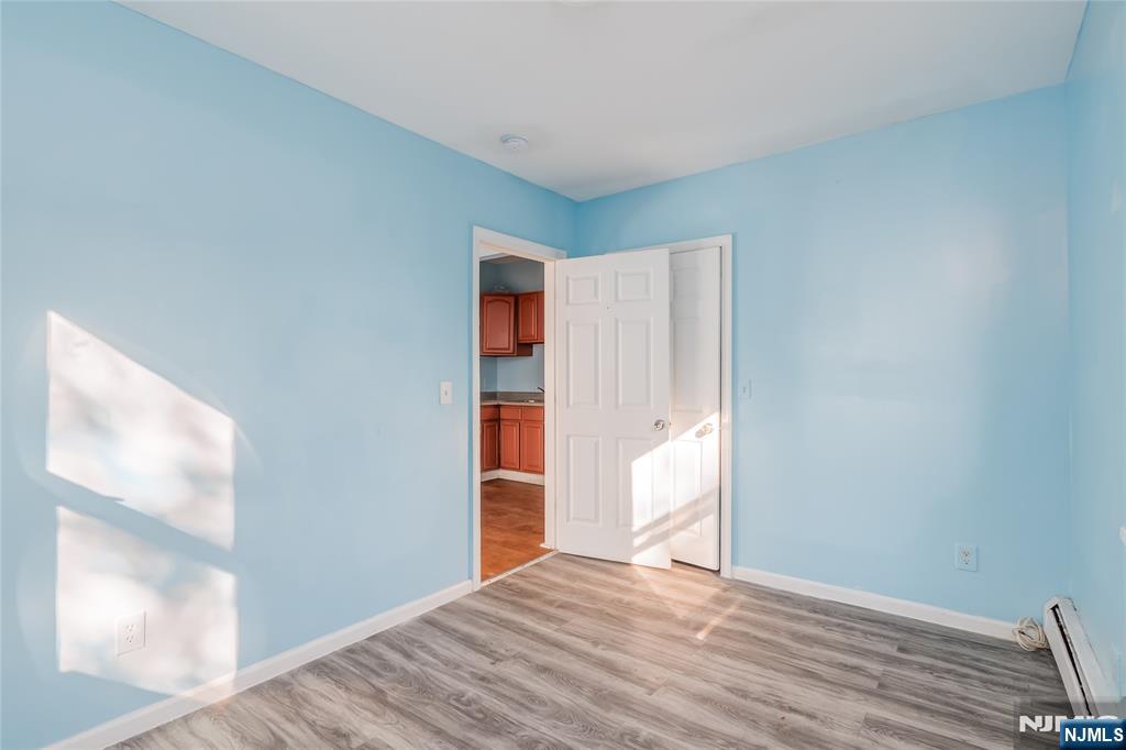 114 Warren Street Paterson, NJ 07524 - Photo 4 of 7 a view of empty room with wooden floor and fan