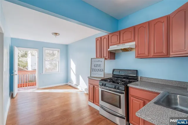 a kitchen with stainless steel appliances granite countertop a stove a sink and a microwave