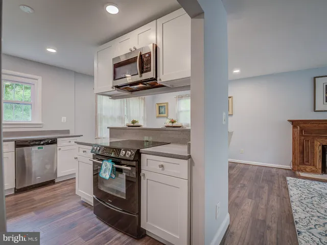 a kitchen with stainless steel appliances granite countertop a stove top oven microwave and cabinets