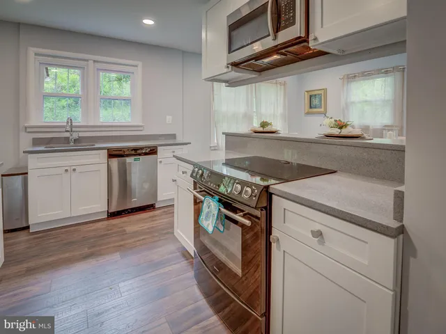 a kitchen with stainless steel appliances granite countertop a stove and a sink