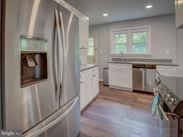 a kitchen with white cabinets and white appliances