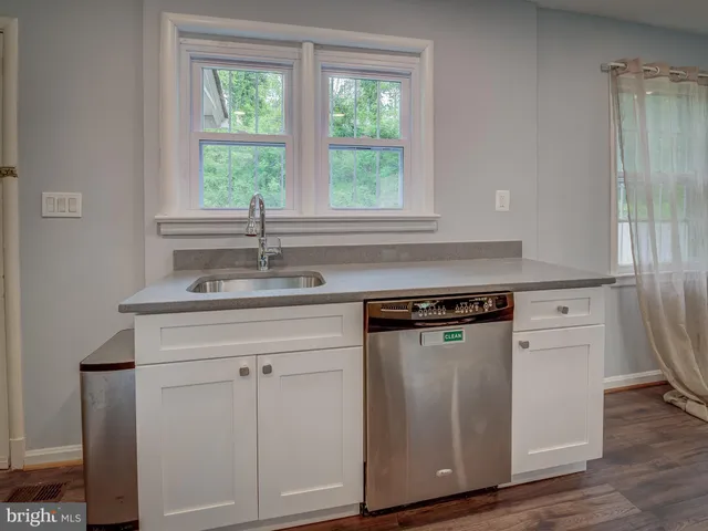 a kitchen with granite countertop a sink cabinets and a window