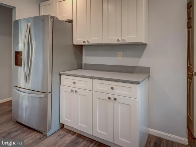 a kitchen with stainless steel appliances white cabinets and a refrigerator