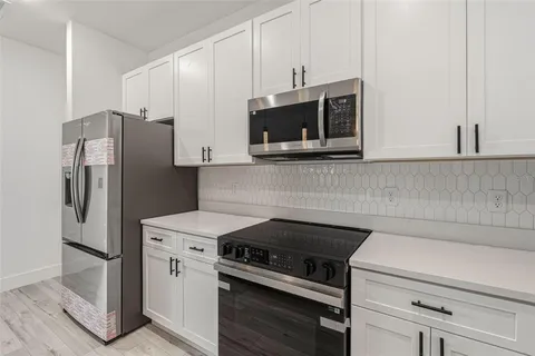 a kitchen with stainless steel appliances a stove microwave and refrigerator