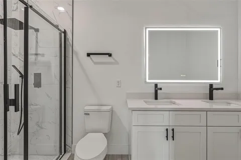 a bathroom with a granite countertop sink toilet and shower