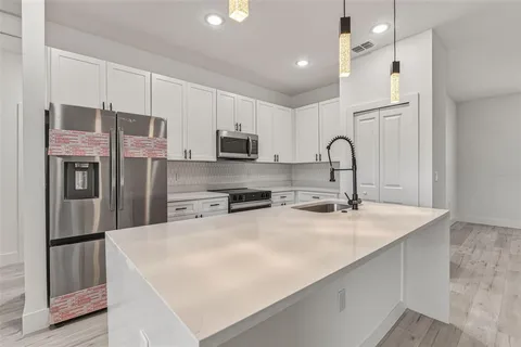 a kitchen with stainless steel appliances a refrigerator sink and cabinets