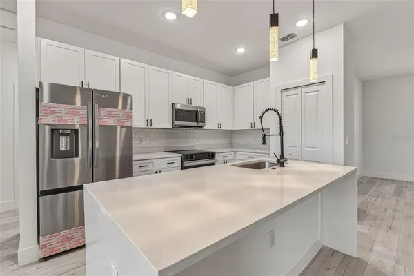 a kitchen with stainless steel appliances a refrigerator sink and cabinets