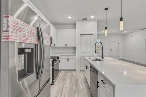 a kitchen with a sink a stove and cabinets